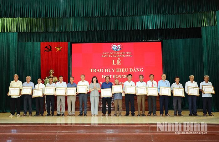 Đồng chí Trần Thị Định, Tỉnh ủy viên, Bí thư Đảng ủy, Chủ tịch HĐND xã trao tặng Huy hiệu Đảng cho các đảng viên.