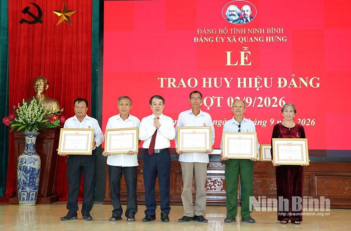 Đồng chí Bùi Hoàng Hà, Ủy viên Ban Thường vụ Tỉnh ủy, Phó Chủ tịch Thường trực HĐND tỉnh trao tặng Huy hiệu Đảng cho các đảng viên xã Quang Hưng.
