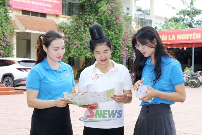 Viên chức BHXH tỉnh phát tờ rơi tuyên truyền chính sách BHYT cho phụ huynh học sinh trên địa bàn phường Chiềng An.