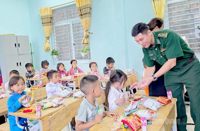 Cán bộ Đồn Biên phòng Thàng Tín chia quà cho học sinh Trường PTDT bán trú Tiểu học & THCS Thàng Tín.