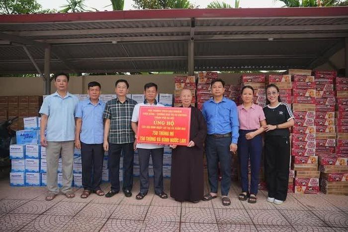 Ni trưởng Thích Đàm Khoa cùng Phật tử chùa Bằng trao quà hỗ trợ người dân vùng lũ xã Xuân Mai