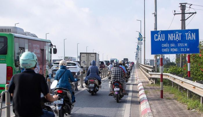 Người dân di chuyển khó khăn qua cầu Nhật Tân. 