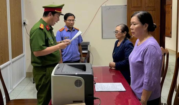 Cán bộ Công an tỉnh Gia Lai đọc lệnh khởi tố bị can đối với bà Bùi Thị Phú và Nguyễn Thị Mai. (Ảnh: Văn Tài).