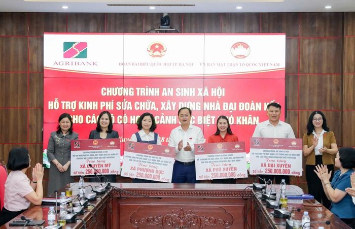 Đồng chí Tô Huy Vũ trao biểu trưng 1 tỷ đồng của Agribank hỗ trợ sửa chữa, xây dựng Nhà Đại đoàn kết cho các hộ gia đình có hoàn cảnh đặc biệt khó khăn tại 4 xã Phú Xuyên, Chuyên Mỹ, Phượng Dực và Đại Xuyên