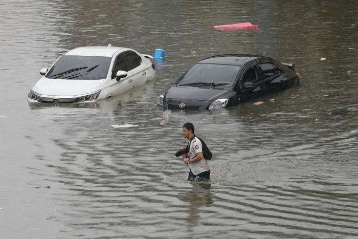  Người đàn ông lội qua vùng nước lũ sau trận mưa lớn ở Bangkok, Thái Lan. (Ảnh: AP)