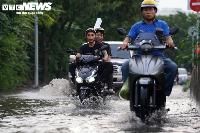 Khoảng 17h20, tại đại lộ Nguyễn Văn Linh, khu vực dưới chân cầu Phú Mỹ, nước từ rạch Cả Cấm dâng cao, tràn vào lòng đường. Người đi xe máy phải di chuyển chậm để tránh bị chết máy khi qua những đoạn ngập.