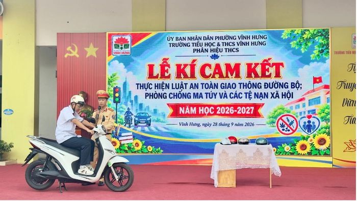 Đại úy Lê Văn Hường, Đội Cảnh sát giao thông đường bộ số 14, hướng dẫn học sinh thực hiện các quy định khi tham gia giao thông. Ảnh: PV