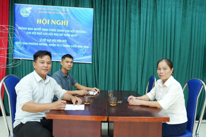 Bà Nguyễn Thị Nhung và ông Hoàng Minh Toàn (áo trắng bên trái) cùng trao đổi công việc tại thôn. Ảnh: Chí Kiên