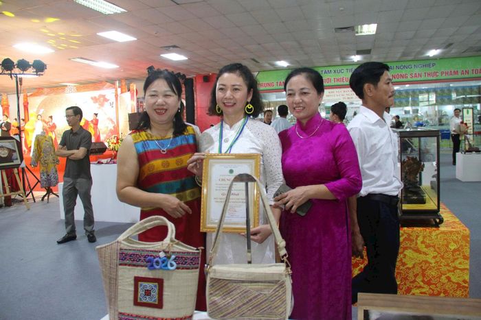Chị Nguyễn Thị Thủy (đứng giữa) và tác phẩm đạt giải nhất Túi xách " Sơn nữ thượng lưu" tại hội thi.