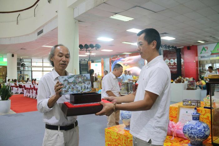 Ông Nguyễn Văn Dũng (bên trái) và tác phẩm “Hộp khảm Bách Nhi” giải đặc biệt tại hội thi.