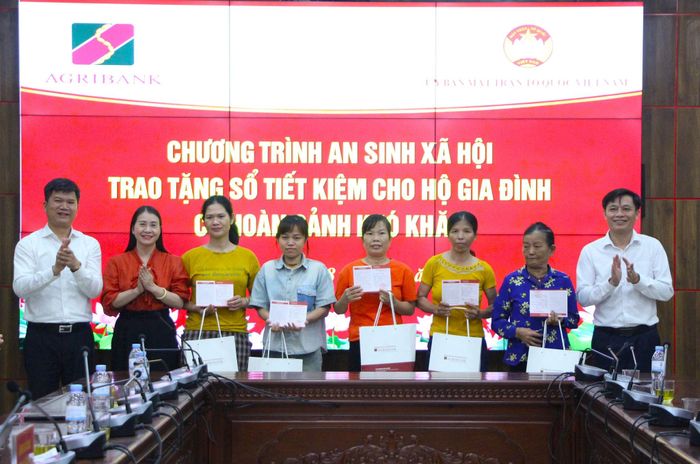 Lãnh đạo Agribank và xã Phú Xuyên trao hỗ trợ sổ tiết kiệm cho 10 hộ gia đình. Ảnh: MH