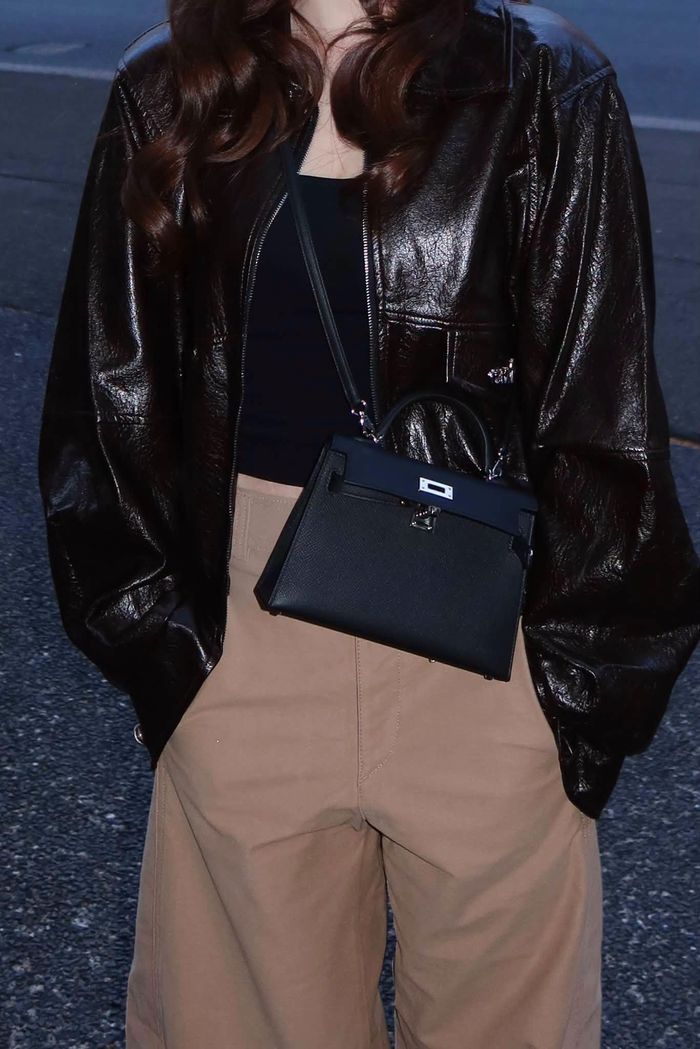 Điểm nhấn của outfit checkin Sydney của Hòa Minzy là mẫu túi dòng Hermès Kelly Sellier (size mini) phiên bản màu đen kết hợp với khóa bạc. Giá của dòng túi xa xỉ bán lẻ tại cửa hàng chính hãng dao động từ 10.500 - 11.500 USD ( khoảng 260 - 285 triệu VNĐ ).