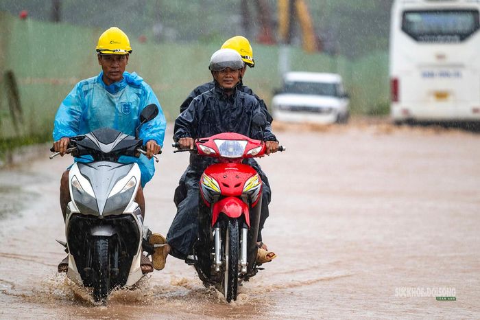 Công nhân di chuyển qua tuyến đường ngập nước để vào công trường.. Ảnh: Hoàng Hà.