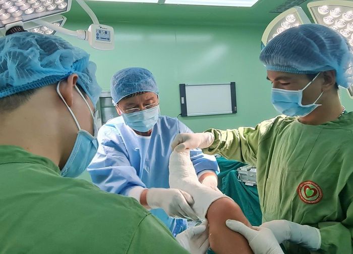 Bác sĩ René D. Esser(giữa) đang nắn sửa chân dị tật cho một bệnh nhân. (Ảnh: Minh Diệu)
