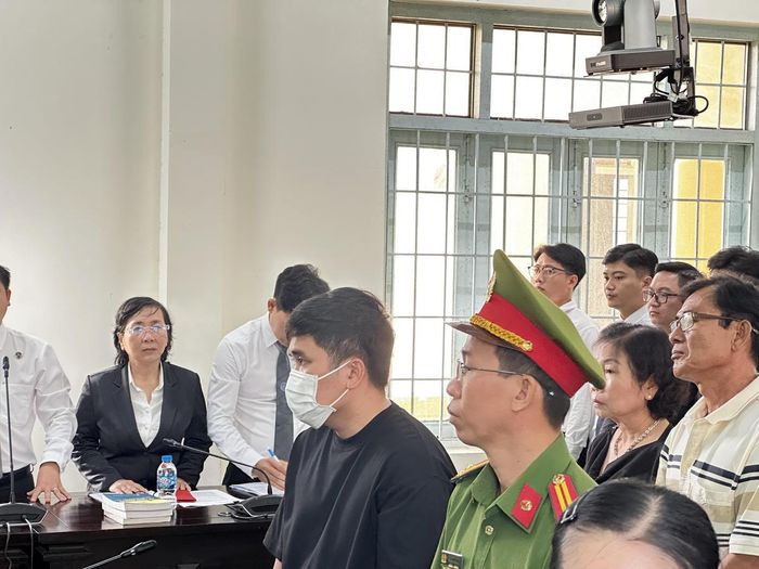 Bị cáo Trung (đeo khẩu trang) tại toà. (Ảnh: Trung Ngãi).