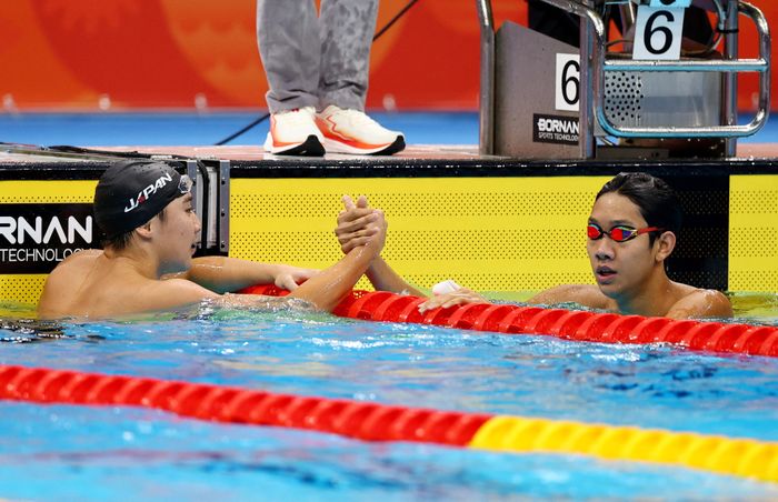  Zhang Zhanshuo (đeo kính) ăn mừng sau khi giành huy chương vàng trong trận chung kết 400 m tự do nam cùng với VĐV đoạt huy chương bạc Kazushi Imafuku của Nhật Bản. Ảnh: Reuters. 