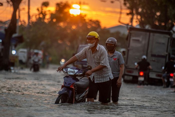  Một người dân phải dắt bộ sau khi cố vượt qua vùng nước ngập. Ảnh: Duy Hiệu. 