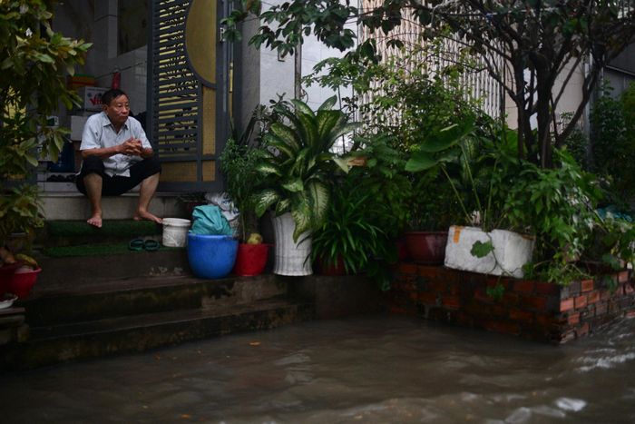  Ông Trần Thế Bình, người dân sống tại đường Nguyễn Bình, cho biết mỗi tháng đường này ngập khoảng hơn 10 ngày, vài ngày cuối tháng và thêm vài ngày giữa tháng âm lịch. "Tôi sống ở đây hơn 50 năm, càng ngày nước triều cường càng dâng cao, ngày trước chỉ ngập mặt đường, sau đó ngập lên vỉa hè rồi vào nhà dân. Tôi xây nền nhà cao hơn mặt đường 1,5 mét để tránh ngập", ông Bình chia sẻ. Ảnh: Duy Hiệu. 