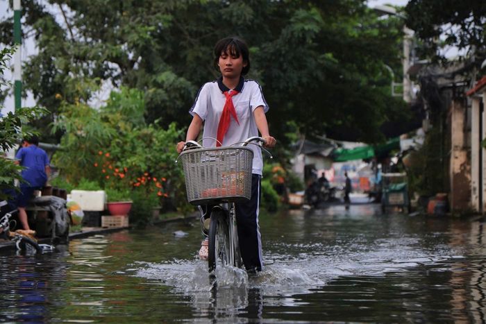  Vào 17h30, triều cường kênh Đôi gây ngập nặng tại khu vực phà Phú Định, đường Rạch Cùng (phường Bình Đông). Nước ngập vào giờ tan tầm khiến việc đi lại của người dân, học sinh khó khăn. Ảnh: Võ Kỳ. 