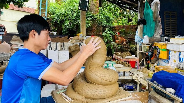 Nghệ nhân trẻ Lê Văn Nhật chế tác linh vật gốm tại cơ sở gia đình
