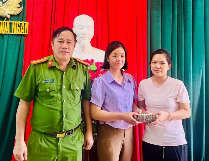 Cô giáo Lường Thị Tâm trao trả 190 triệu đồng cho chị Từ Thị Vân Anh được anh Giang Bá Phủ ủy quyền. Ảnh: Công an xã Núa Ngam