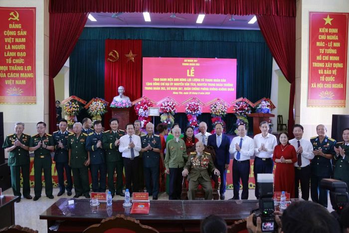 Các đại biểu chụp ảnh lưu niệm cùng Anh hùng Lực lượng vũ trang nhân dân Nguyễn Văn Tích. (Ảnh: Mai Tú)