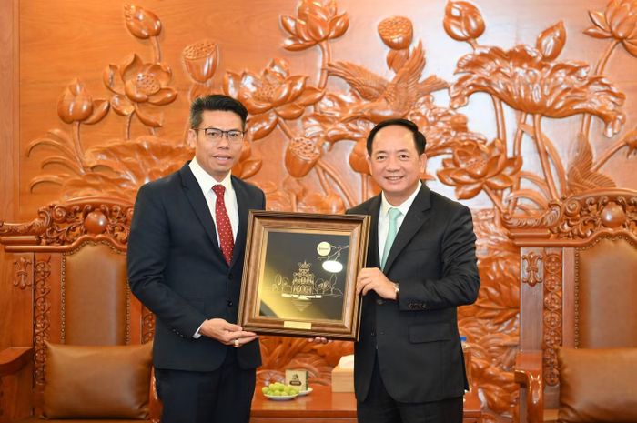 Đồng chí Trịnh Văn Quyết trao quà tặng đồng chí Sả Khon Phôm Mạ Lạt. (Ảnh: THẾ ĐẠI)