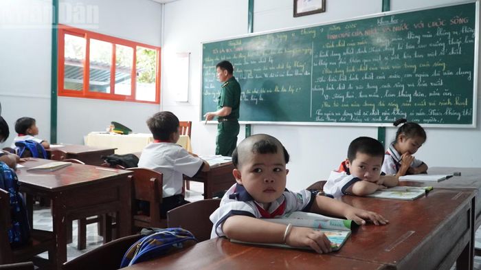 Thầy giáo Trần Bình Phục đang dạy học cho các em nhỏ tại đảo Hòn Chuối.