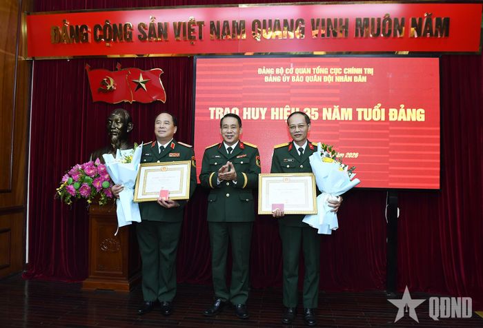 Đại tá Ngô Anh Thu, Phó bí thư Đảng ủy, Phó tổng biên tập Báo Quân đội nhân dân trao Huy hiệu 35 năm tuổi Đảng và tặng hoa chúc mừng các đảng viên.