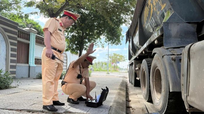 Lực lượng chức năng tập trung kiểm tra phương tiện có dấu hiệu chở hàng vượt quá tải trọng.