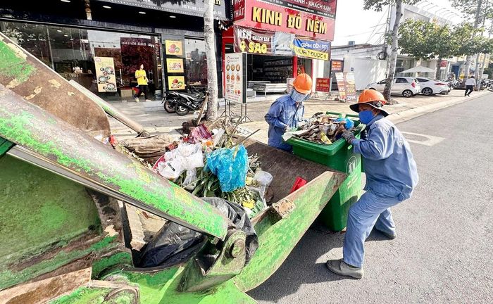  Công nhân vệ sinh môi trường Công ty CP Môi trường đô thị Bà Rịa thu gom rác bằng xe chuyên dụng. Ảnh: QUANG VŨ 