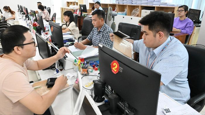  Công chức Trung tâm Phục vụ hành chính công phường Xuân Hòa, TPHCM tiếp nhận, giải quyết hồ sơ cho người dân. Ảnh: VIỆT DŨNG 