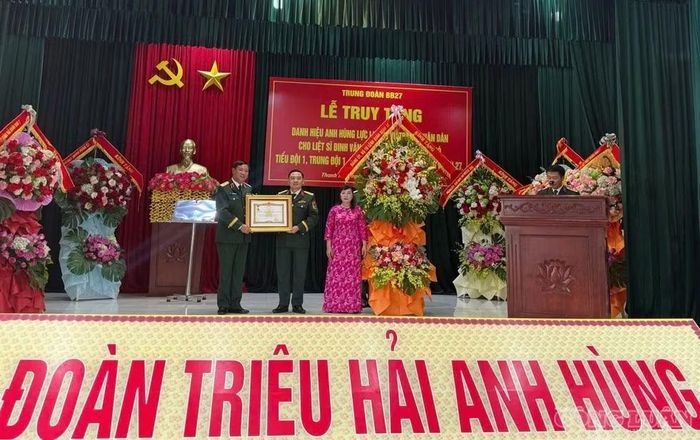 Thiếu tướng Nguyễn Thanh Tình, Phó Chính ủy Quân đoàn 12, trao danh hiệu Anh hùng Lực lượng vũ trang nhân dân đến gia đình liệt sĩ Đinh Văn Kiên (Ảnh: Bích Trang).