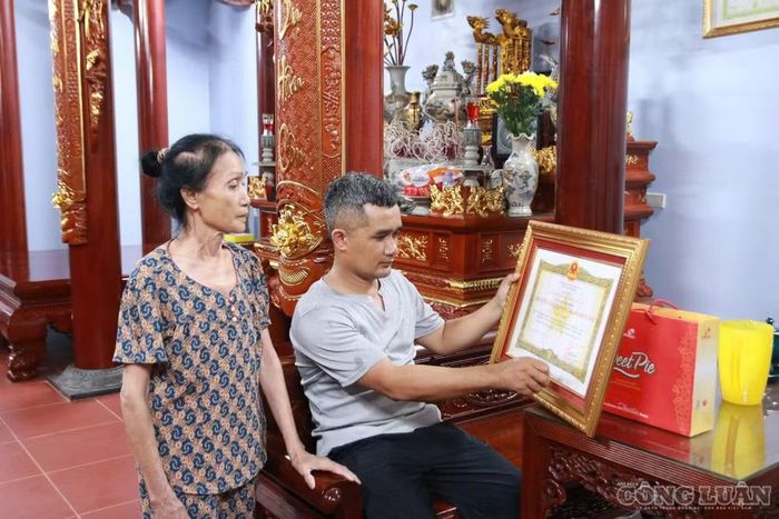  Người thân bên danh hiệu cao quý Đảng, Nhà nước ghi nhận những công lao của liệt sĩ Đinh Văn Kiên. ﻿Ảnh: Kim Long 