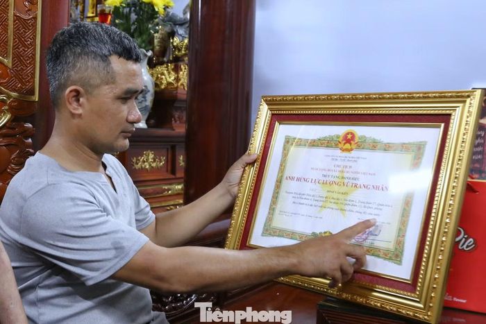 Người thân liệt sĩ Đinh Văn Kiên xúc động bên danh hiệu Anh hùng Lực lượng vũ trang nhân dân.
