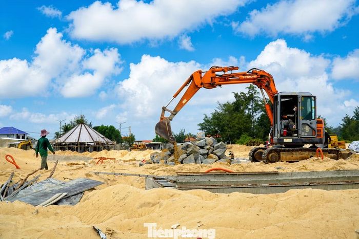 Máy móc, phương tiện thi công hoạt động liên tục trên công trường. Các hạng mục nền quảng trường, mặt bằng công viên đang trong giai đoạn thi công, nhằm tạo nên diện mạo mới thay cho khu vực từng là nghĩa địa âm u, hiu hắt, dày đặc mồ mả ven biển.