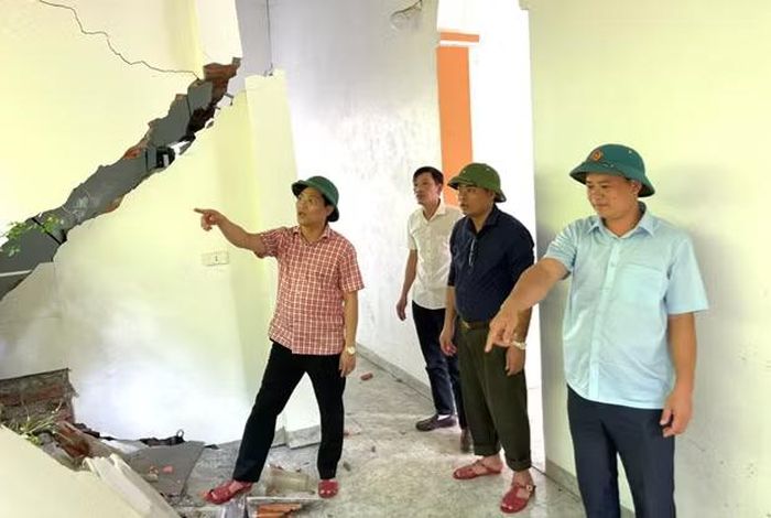 Bí thư Đảng ủy xã Đồng Lương Hoàng Văn Thanh (bìa trái) cùng đoàn công tác kiểm tra sạt lở gây hư hỏng nhà dân.