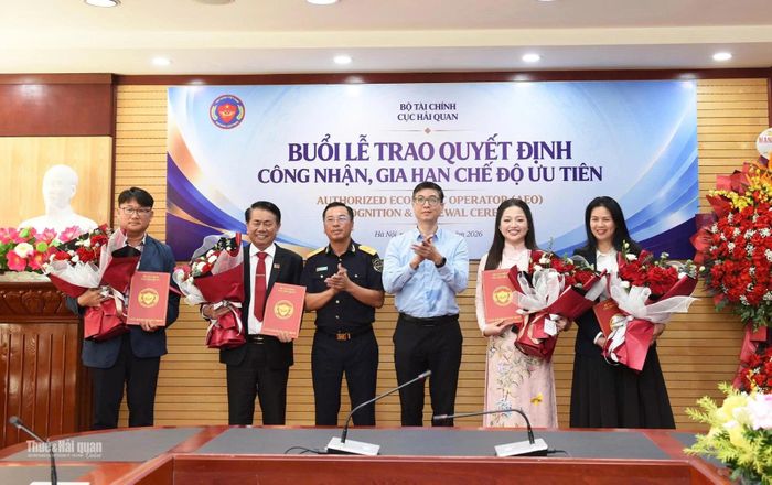Phó Cục trưởng Cục Hải quan Trần Đức Hùng (thứ 3 bên trái sang) và Phó Cục trưởng Cục Đầu tư nước ngoài (Bộ Tài chính) Trương Minh trao quyết định gia hạn và tặng hoa cho 4 doanh nghiệp. Ảnh: Thái Bình