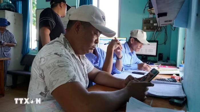 Ngư dân thực hiện khai báo điện tử trước khi vươn khơi. (Ảnh: Đình Quân/TTXVN)
