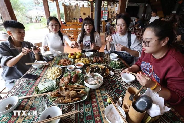 Du khách thưởng thức ẩm thực tại Làng du lịch cộng đồng xã Hữu Liên (Lạng Sơn). (Ảnh: Anh Tuấn/TTXVN)