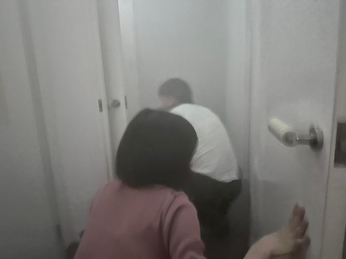 Khách tham quan cúi thấp người để di chuyển khi trải nghiệm thoát hiểm trong căn phòng ngập khói.