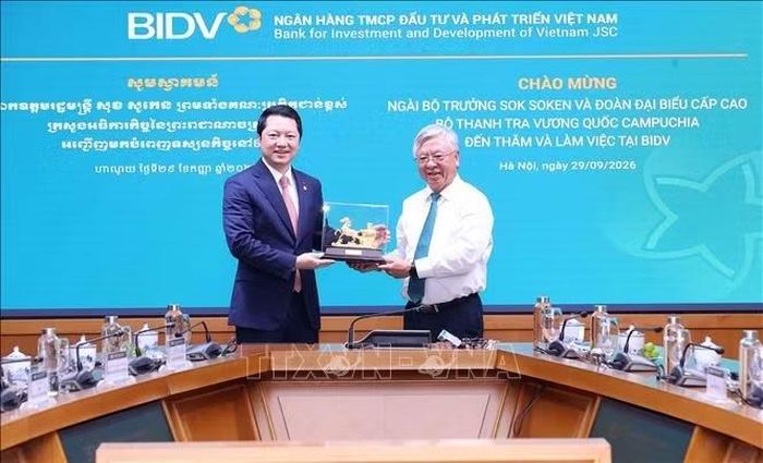 Lãnh đạo Ngân hàng Thương mại cổ phần Đầu tư và Phát triển Việt Nam tặng quà lưu niệm cho Bộ trưởng Bộ Thanh tra Vương quốc Campuchia Sok Soken. Ảnh: Văn Điệp/TTXVN