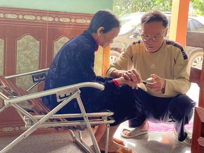 Cụ Trần Thị Duyên bên người con út Trần Hữu Sự, người cùng gia đình bền bỉ thực hiện tâm nguyện đưa liệt sĩ Trần Hữu Quân trở về quê hương.