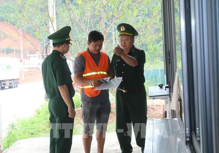 BĐBP cửa khẩu Tân Thanh hướng dẫn thủ tục lưu thông hàng hóa tại khu vực mốc 1088/2-1089. Ảnh: Quang Duy – TTXVN