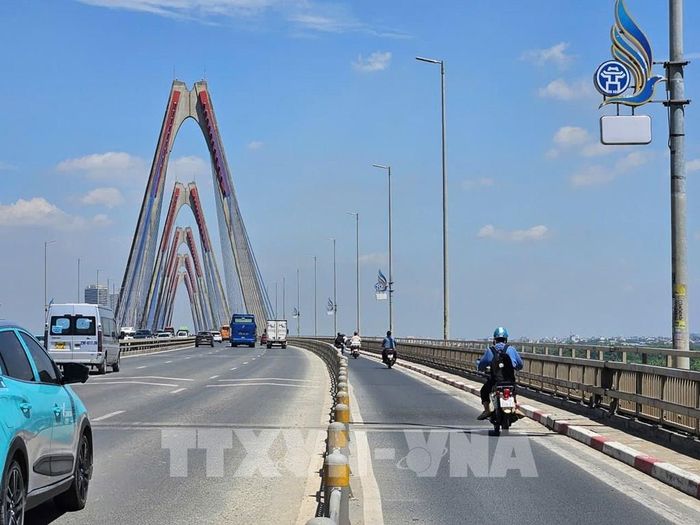 Các phương tiện lưu thông qua cầu Nhật Tân sau khi biển chỉ dẫn khoảng cách được tạm thu hồi. Ảnh: TTXVN phát