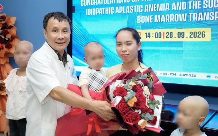 GS.TS Phạm Như Hiệp, Giám đốc Bệnh viện Trung ương Huế, tặng hoa chức mừng mẹ con bệnh nhi P.T.M.D. trước giờ ra viện