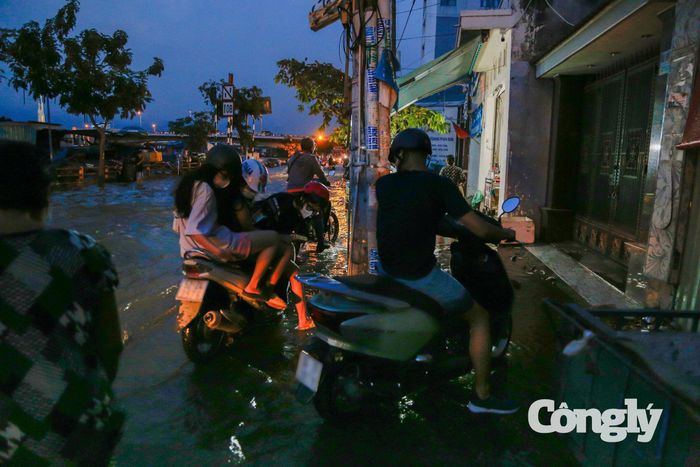 Nhiều người phải leo lên vỉa hè chờ bớt ngập.