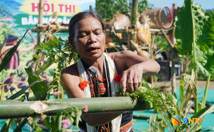 Mẹ làng làm nghi lễ đón nhận nguồn nước được đưa về làng. Ảnh: PHAN VINH