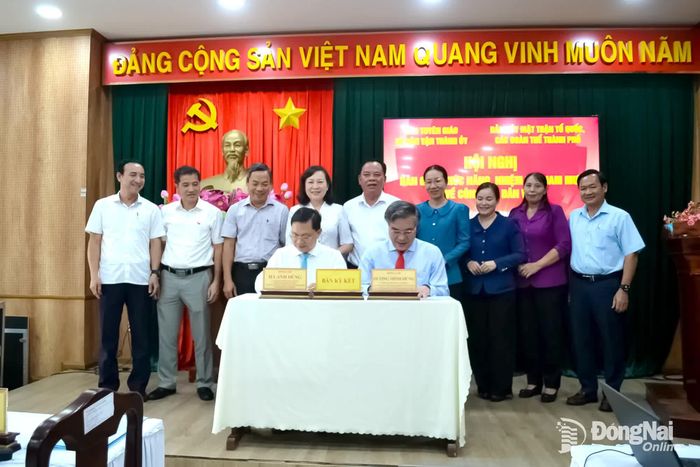 Đồng chí Dương Minh Dũng, Ủy viên Ban Thường vụ Thành ủy, Trưởng ban Tuyên giáo và Dân vận Thành ủy - đại diện bên giao và đồng chí Hà Anh Dũng, Ủy viên Ban Thường vụ Thành ủy, Phó Bí thư Thường trực Đảng ủy MTTQ, các đoàn thể thành phố, Phó Chủ tịch Thường trực Ủy ban MTTQ Việt Nam thành phố - đại diện bên nhận, ký Biên bản bàn giao trước sự chứng kiến của Thường trực Thành ủy và lãnh đạo các đơn vị. Ảnh: Phương Hằng