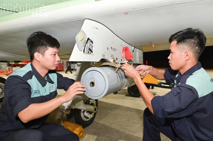 Nhân viên kỹ thuật hàng không treo bom lên máy bay.